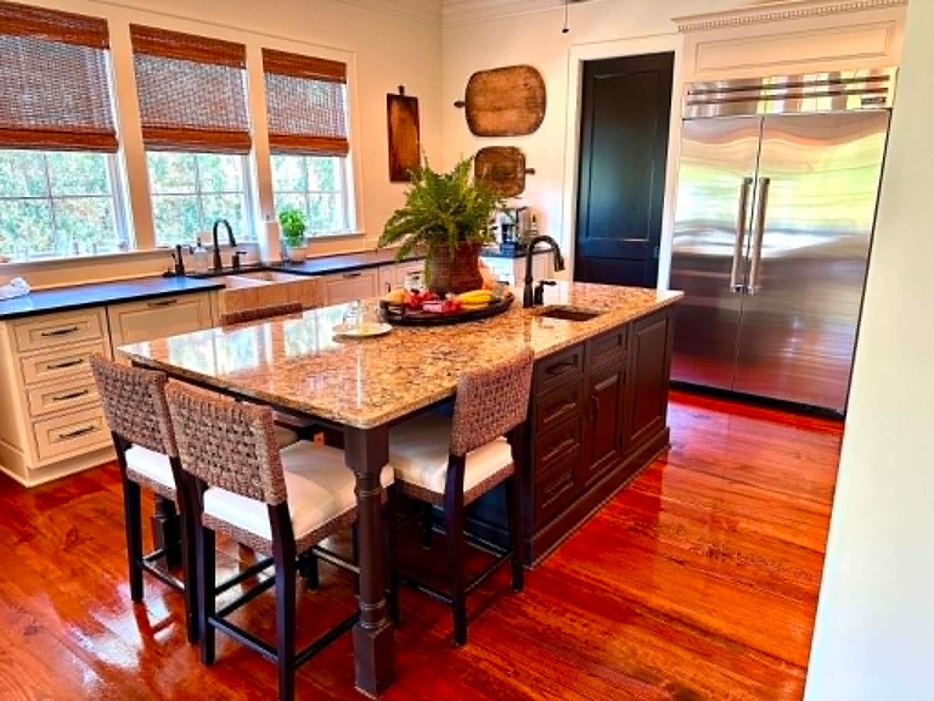 Warm kitchen with granite island and stainless appliances, freshly cleaned