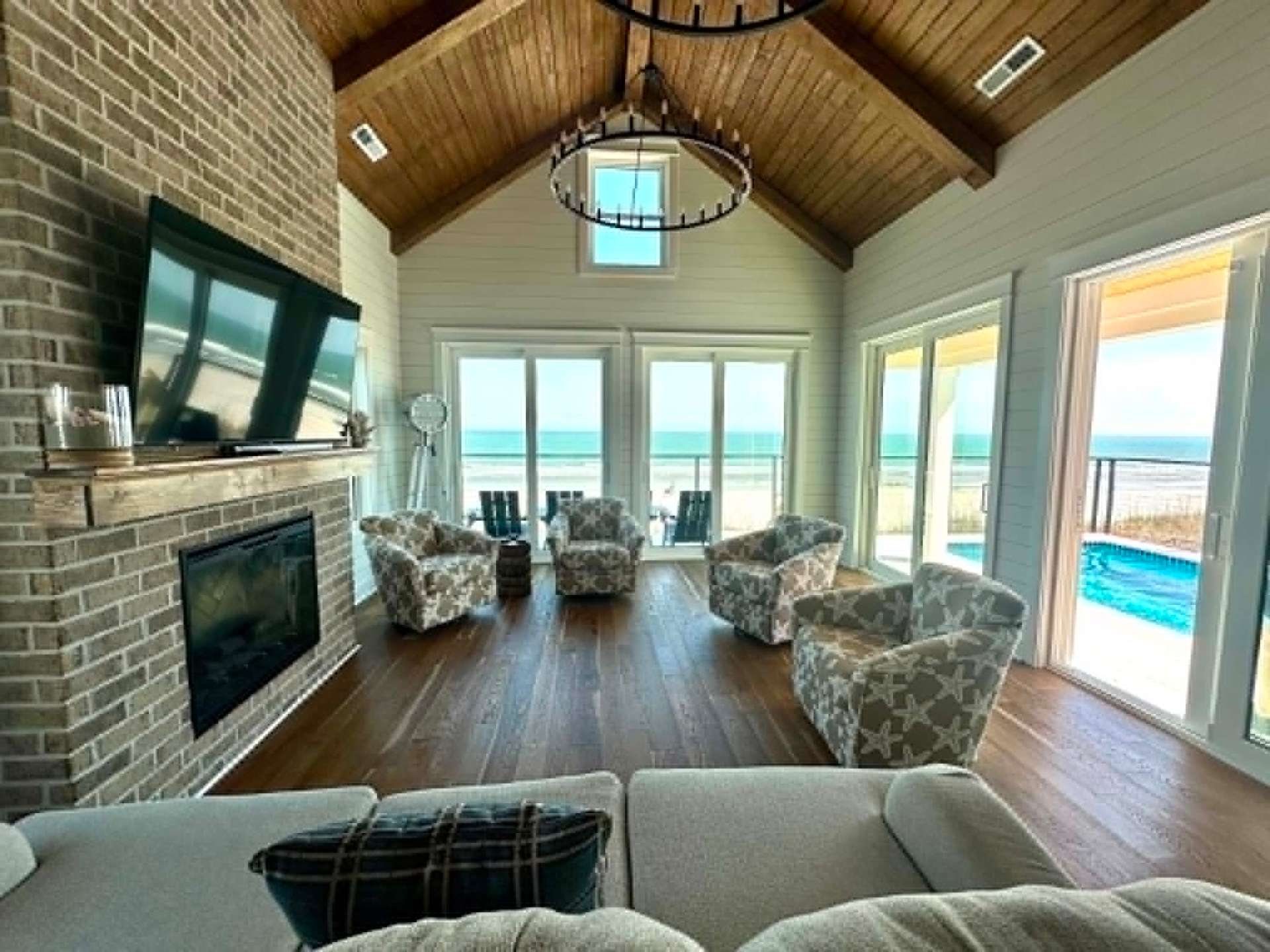 Oceanfront living room with vaulted ceiling and beach views, freshly cleaned